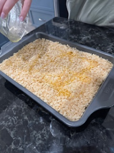 Golden crispy Rice Krispie topping on a baked chicken and rice casserole recipe in a pan