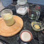 Homemade avocado oil mayonnaise in a glass mason jar on a dark granite countertop