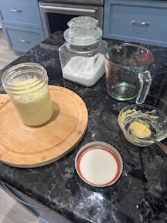Homemade avocado oil mayonnaise in a glass mason jar on a dark granite countertop