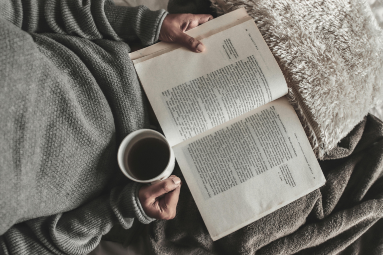 Cozy reading setup with The Chief by Monica McCarty, a mug of tea, and a plaid blanket on a wooden table