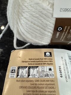 Reading a yarn label by looking at the skein of yarn with the wrapper notations.