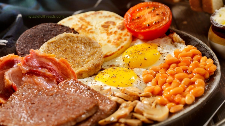 Full Scottish breakfast with a plate full of food that is rich with tradition. tomatoes, beans, tattie, bacon, eggs, mushrooms.